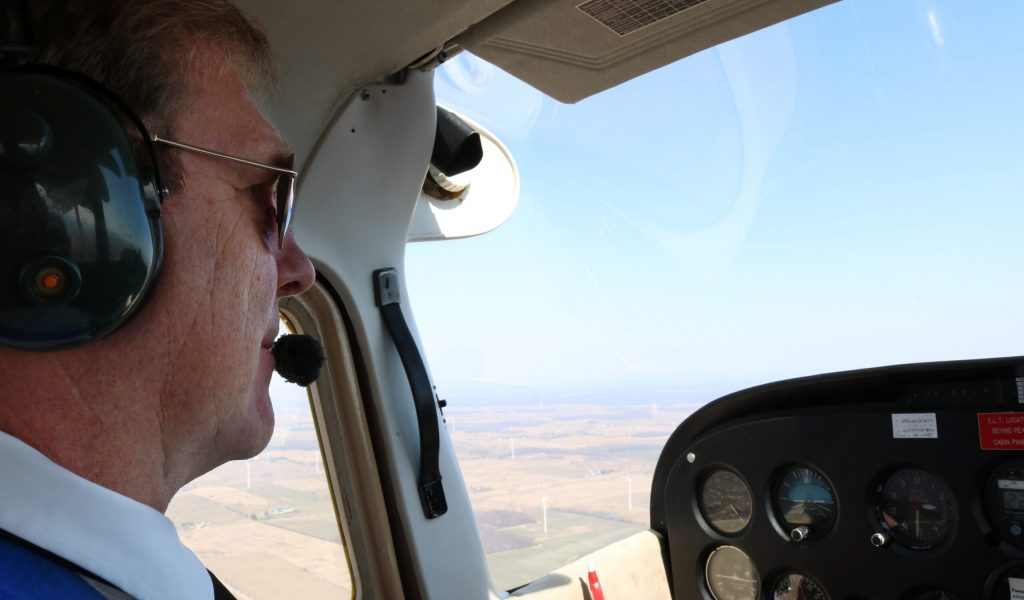 Male,Caucasian,Pilot,Flying,A,Plane,On,A,Sunny,Day